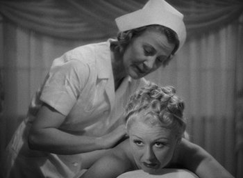 Movie still from “The Women” (1939), directed by George Cukor – An older woman is getting a massage from a nurse; Medium shot, High angle