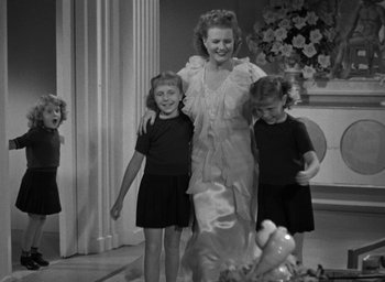 Movie still from “The Women” (1939), directed by George Cukor – A black and white photo of a woman and two young girls; Medium shot, Low angle