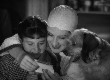 Movie still from “The Women” (1939), directed by George Cukor – Two women and a child looking at a cell phone; Close Up shot, Over the shoulder angle