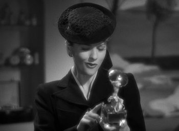 Movie still from “The Women” (1939), directed by George Cukor – A black and white photo of a woman holding a perfume bottle; Close Up shot, Low angle