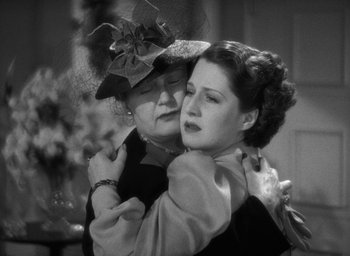 Movie still from “The Women” (1939), directed by George Cukor – Two women embracing each other in a black and white photo; Close Up shot, High angle