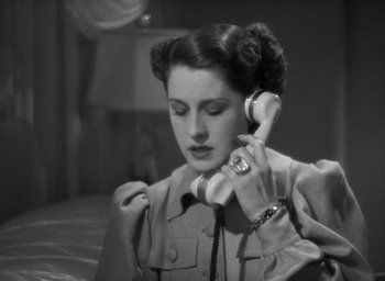 Movie still from “The Women” (1939), directed by George Cukor – A woman holding a phone up to her ear; Close Up shot, High angle