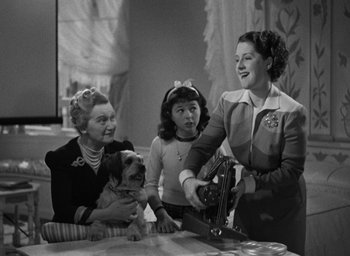 Movie still from “The Women” (1939), directed by George Cukor – Three women and a small dog are in a room; Medium shot, Low angle