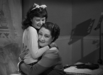 Movie still from “The Women” (1939), directed by George Cukor – A woman and a girl hugging each other in a room; Medium shot, High angle