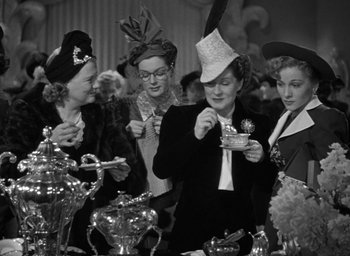 Movie still from “The Women” (1939), directed by George Cukor – A group of women standing next to each other at a table; Medium shot, Low angle