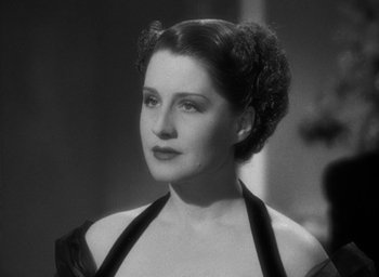 Movie still from “The Women” (1939), directed by George Cukor – An old photo of a woman in a black dress; Close Up shot, Over the shoulder angle