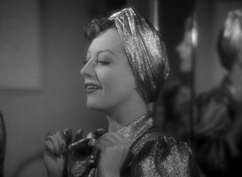 Movie still from “The Women” (1939), directed by George Cukor – A black - and - white photo of a woman wearing a head scarf; Close Up shot, Over the shoulder angle