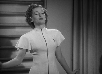 Movie still from “The Women” (1939), directed by George Cukor – A black and white photo of a woman singing; Medium shot, Low angle