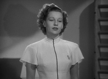 Movie still from “The Women” (1939), directed by George Cukor – A black and white photo of a woman in a white shirt; Medium shot, Low angle