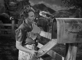 Movie still from “The Women” (1939), directed by George Cukor – An old photo of a woman putting mail in a mailbox; Medium shot, High angle