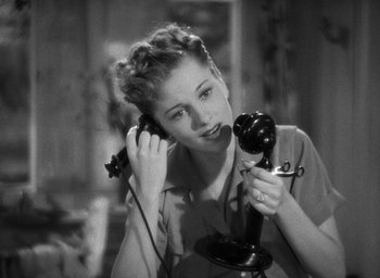 Movie still from “The Women” (1939), directed by George Cukor – A woman is holding a phone up to her ear; Close Up shot, High angle