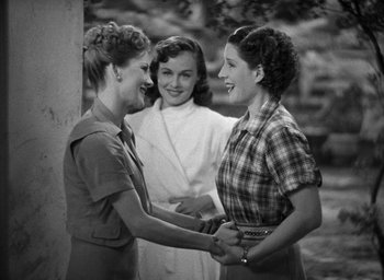 Movie still from “The Women” (1939), directed by George Cukor – A group of young women standing next to each other; Medium shot, Over the shoulder angle