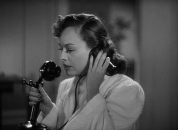 Movie still from “The Women” (1939), directed by George Cukor – A woman is holding a phone up to her ear; Close Up shot, High angle
