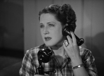 Movie still from “The Women” (1939), directed by George Cukor – A woman holding a phone up to her ear; Close Up shot, High angle