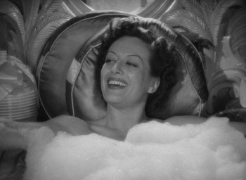Movie still from “The Women” (1939), directed by George Cukor – An old photo of a woman smiling in a bath tub; Close Up shot, Overhead angle
