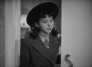 Movie still from “The Women” (1939), directed by George Cukor – A young woman in a hat and a suit; Close Up shot, High angle