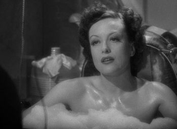 Movie still from “The Women” (1939), directed by George Cukor – An old black and white photo of a woman sitting in a bathtub; Close Up shot, High angle