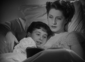 Movie still from “The Women” (1939), directed by George Cukor – A woman and a boy are laying in a bed; Close Up shot, High angle