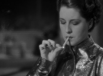 Movie still from “The Women” (1939), directed by George Cukor – A black and white photo of a woman smoking a cigarette; Close Up shot, Low angle