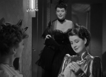 Movie still from “The Women” (1939), directed by George Cukor – Two women are looking in the mirror while one of them is holding a cell phone; Medium shot, Over the shoulder angle