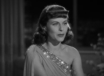 Movie still from “The Women” (1939), directed by George Cukor – A black - and - white photo of a woman wearing a dress; Close Up shot, Over the shoulder angle