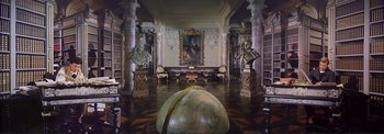 Movie still from “The Wonderful World of the Brothers Grimm” (1962), directed by Henry Levin – A room filled with lots of furniture and a large painting on the wall; Extreme Wide shot, High angle