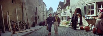 Movie still from “The Wonderful World of the Brothers Grimm” (1962), directed by Henry Levin – A couple of men walking down a street holding hands; Wide shot, Low angle