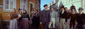 Movie still from “The Wonderful World of the Brothers Grimm” (1962), directed by Henry Levin – A group of people standing on a street; Wide shot, Low angle