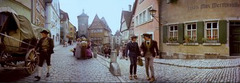 Movie still from “The Wonderful World of the Brothers Grimm” (1962), directed by Henry Levin – A couple of men standing next to each other on a street; Wide shot, High angle
