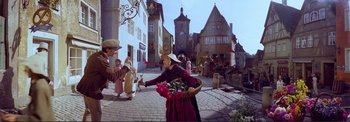 Movie still from “The Wonderful World of the Brothers Grimm” (1962), directed by Henry Levin – A woman in costume holding a basket of flowers; Wide shot, High angle