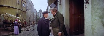 Movie still from “The Wonderful World of the Brothers Grimm” (1962), directed by Henry Levin – Two men standing next to each other on a street; Medium shot, Over the shoulder angle