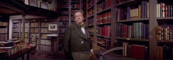 Movie still from “The Wonderful World of the Brothers Grimm” (1962), directed by Henry Levin – A man standing in front of a book shelf; Medium shot, Low angle