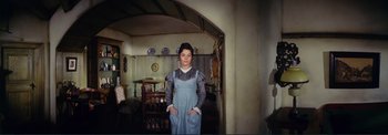 Movie still from “The Wonderful World of the Brothers Grimm” (1962), directed by Henry Levin – A woman standing in a room wearing a blue dress; Medium shot, High angle