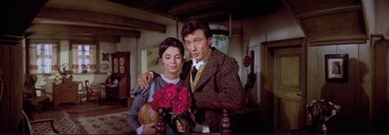 Movie still from “The Wonderful World of the Brothers Grimm” (1962), directed by Henry Levin – A man and a woman standing next to each other holding flowers; Medium shot, High angle