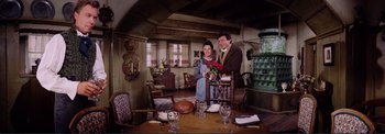 Movie still from “The Wonderful World of the Brothers Grimm” (1962), directed by Henry Levin – A man and a woman standing at a dining room table; Wide shot, High angle