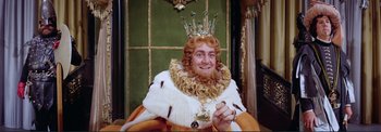 Movie still from “The Wonderful World of the Brothers Grimm” (1962), directed by Henry Levin – A man with a beard and a crown sitting in a chair; Medium shot, High angle