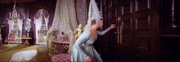 Movie still from “The Wonderful World of the Brothers Grimm” (1962), directed by Henry Levin – A woman dressed as a princess opening a door; Medium shot, High angle