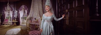 Movie still from “The Wonderful World of the Brothers Grimm” (1962), directed by Henry Levin – A woman dressed as a princess in front of a door; Medium shot, High angle