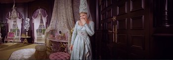 Movie still from “The Wonderful World of the Brothers Grimm” (1962), directed by Henry Levin – A woman dressed in a green dress with a veil on her head; Medium shot, High angle