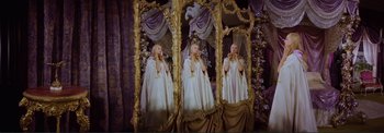 Movie still from “The Wonderful World of the Brothers Grimm” (1962), directed by Henry Levin – A woman in a white dress standing in front of a mirror; Wide shot, High angle