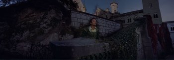 Movie still from “The Wonderful World of the Brothers Grimm” (1962), directed by Henry Levin – A man standing next to a stone wall at night; Wide shot, Low angle