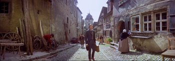 Movie still from “The Wonderful World of the Brothers Grimm” (1962), directed by Henry Levin – A man is walking down the street holding a briefcase; Wide shot, Low angle