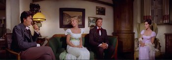 Movie still from “The Wonderful World of the Brothers Grimm” (1962), directed by Henry Levin – A man and a woman sitting on a green couch; Medium shot, Low angle