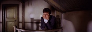 Movie still from “The Wonderful World of the Brothers Grimm” (1962), directed by Henry Levin – A man leaning on the railing of a staircase; Close Up shot, High angle