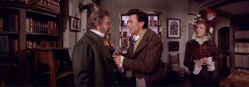 Movie still from “The Wonderful World of the Brothers Grimm” (1962), directed by Henry Levin – Two men in suits and ties , one of which is holding a tie; Medium shot, Over the shoulder angle