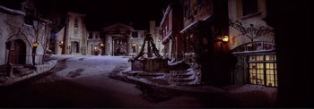 Movie still from “The Wonderful World of the Brothers Grimm” (1962), directed by Henry Levin – A street scene with snow on the ground and buildings; Extreme Wide shot, High angle