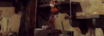 A toy elf is standing next to a hat