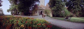 Movie still from “The Wonderful World of the Brothers Grimm” (1962), directed by Henry Levin – A man walking in front of an old building; Wide shot, Low angle