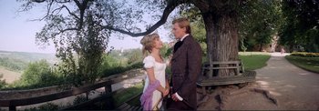 Movie still from “The Wonderful World of the Brothers Grimm” (1962), directed by Henry Levin – A man and a woman standing next to each other under a tree; Medium shot, High angle