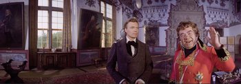 Movie still from “The Wonderful World of the Brothers Grimm” (1962), directed by Henry Levin – A man standing in a room with paintings on the walls; Medium shot, Low angle